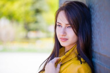 Yakın çekim portre sarı ceketli genç güzel esmer açık havada sokak bahar