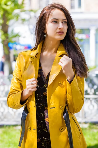 春黄色のジャケットの若い美しいブルネットのクローズ アップの肖像画の屋外ストリート — ストック写真