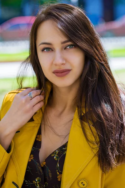 Yakın çekim portre sarı ceketli genç güzel esmer açık havada sokak bahar