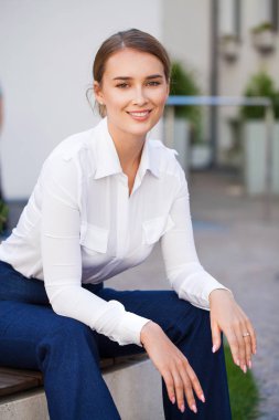 Bir parkta bir bankta oturan bir tam uzunlukta genç güzel iş kadın portresi