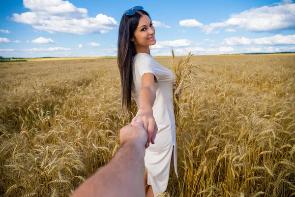 私に従ってください 美しいセクシーな若い女性は 麦畑で男の手を保持しています — ストック写真