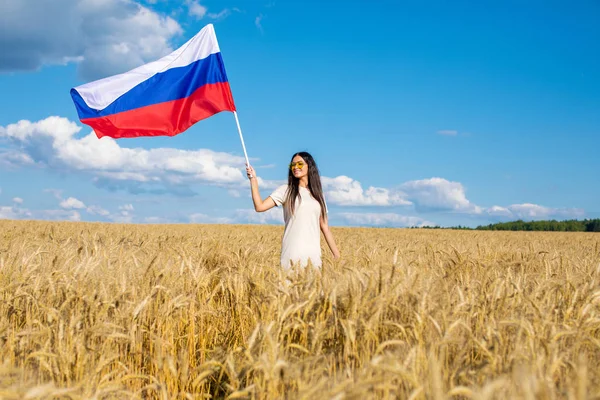 黄金の麦畑 真夏の野外でロシア国旗を振っている美しい少女 — ストック写真