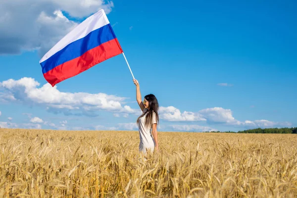 黄金の麦畑 真夏の野外でロシア国旗を振っている美しい少女 — ストック写真