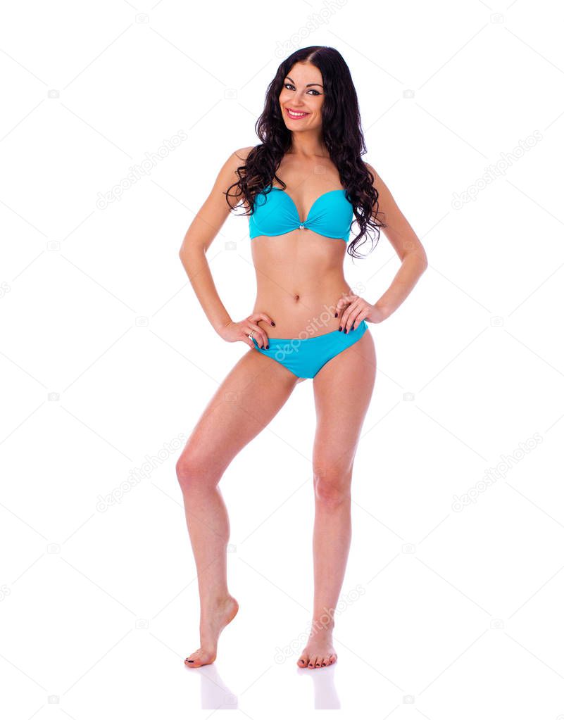 Full length portrait of young brunette woman wearing turquoise bikini, isolated on white background