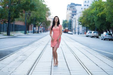 Tam büyüme, üzerinde sokak, yaz açık havada yürüyüş pembe elbiseli Genç güzel esmer kadın portre