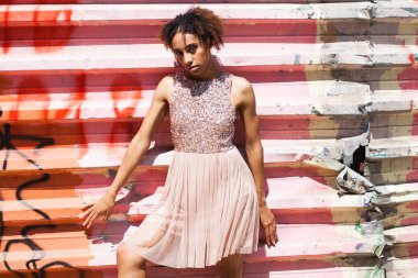 Sokak moda modeli. Pembe elbiseli bir Afrika genç kadın portresi