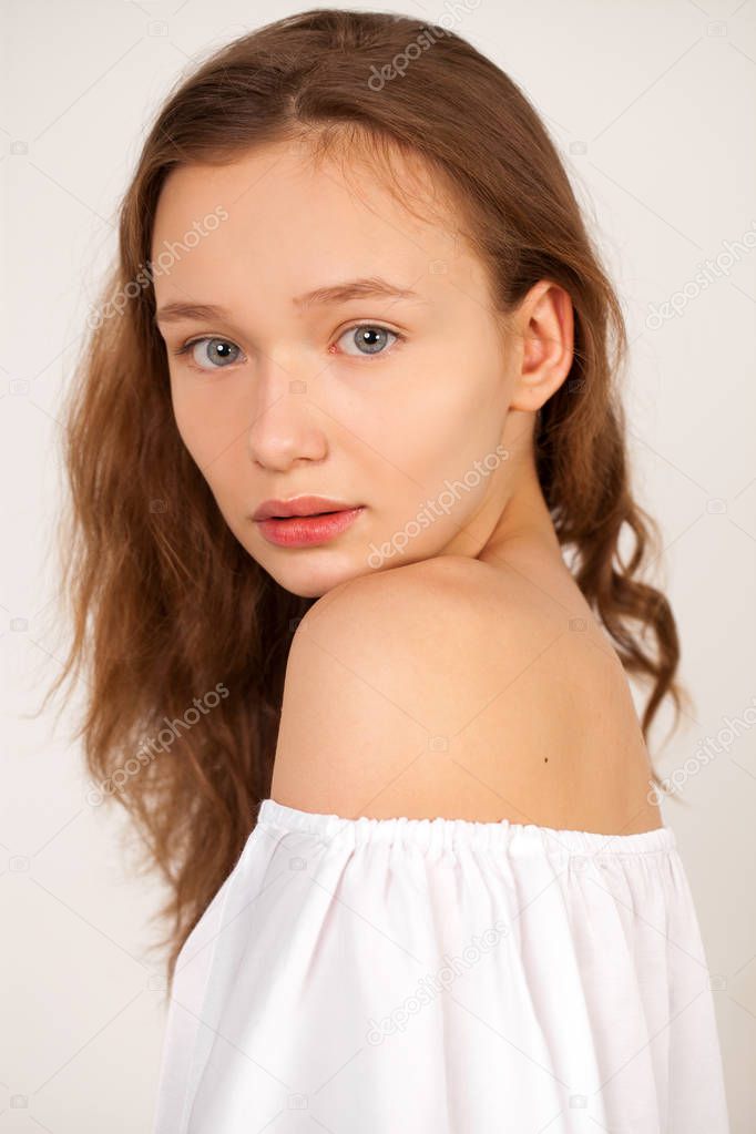 Portrait of a young teen girl close-up without makeup, isolated on red background