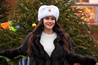 Rus güzellik. Bir kürk şapka kırmızı bir kare Moskova'da karşı beyaz şapkalı güzel bir genç kız portresi