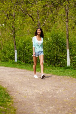 Güzel genç mutlu esmer kadın kot şort, yaz sokak açık havada portresi