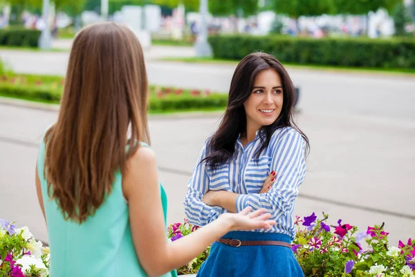 Empty chatter from which the head hurts. Two young women talking on the street — Stock Image Empty Chatter Which Head Hurts Two Young Women Talking Street Stock Photo