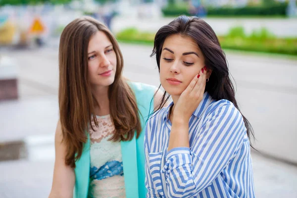 Empty chatter from which the head hurts. Two young women talking on the street — Stock Image Empty Chatter Which Head Hurts Two Young Women Talking Street Royalty Free Stock Images