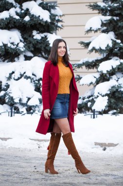 Tam vücut. Genç güzel esmer kadın kırmızı paltolu kış park üzerinde poz. Şık sıcak giysiler giyen modeli.