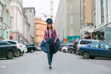 Tam büyümüş portre, mavi kısa elbiseli güzel esmer kadın yolda yürüyor, yaz caddesinde.