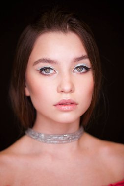 Makyaj modelini kapat. Genç, güzel esmer kız, stüdyo siyah duvar arka planında