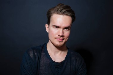 Karanlık bir arka plan üzerinde genç bir adam portresi stüdyo