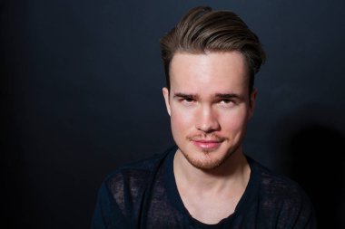 Karanlık bir arka plan üzerinde genç bir adam portresi stüdyo