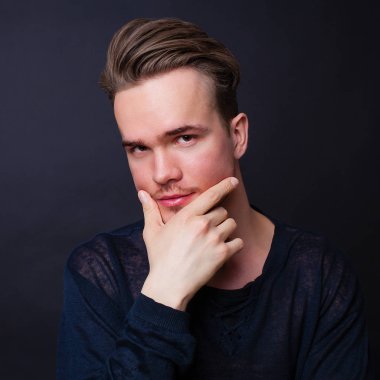 Karanlık bir arka plan üzerinde genç bir adam portresi stüdyo