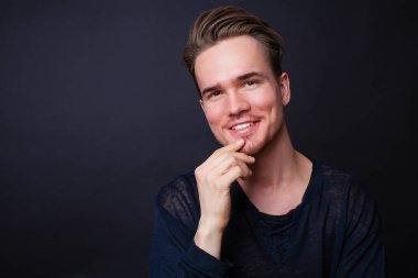 Karanlık bir arka plan üzerinde genç bir adam portresi stüdyo