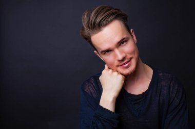 Karanlık bir arka plan üzerinde genç bir adam portresi stüdyo