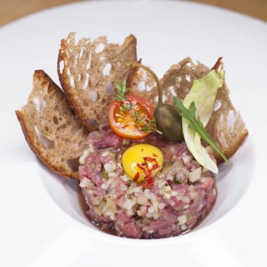 Mermer biftek tartare beyaz bir plaka üzerinde