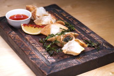 Kızarmış köfte bir ahşap tepsi baharatlı sos ile