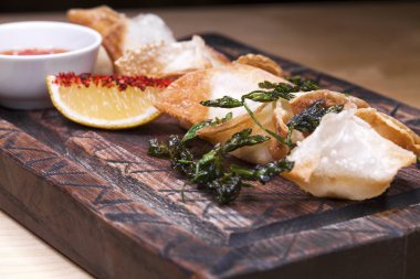 Kızarmış köfte bir ahşap tepsi baharatlı sos ile