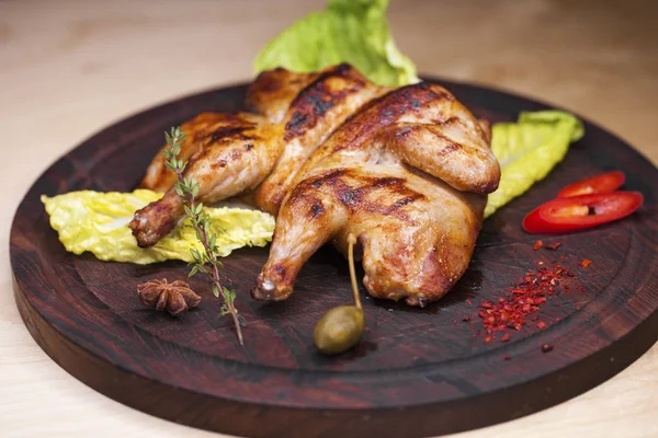 Жареный цыпленок и салат на деревянной доске — стоковое фото