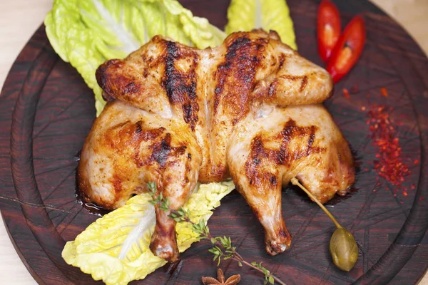 Жареный цыпленок и салат на деревянной доске — стоковое фото