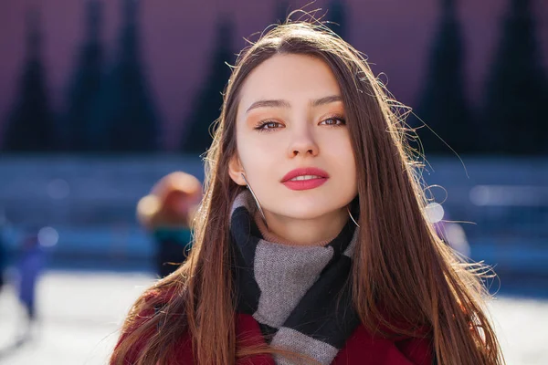 Jovem bela mulher morena em casaco vermelho posando no parque de inverno — Fotografia de Stock