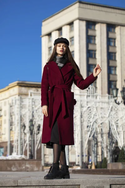 Bella ragazza in elegante in un lungo cappotto bordeaux — Foto Stock