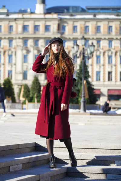 Bella ragazza in elegante in un lungo cappotto bordeaux — Foto Stock