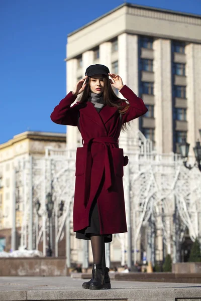 Beautiful girl in stylish in a long burgundy coat — Stock Photo, Image
