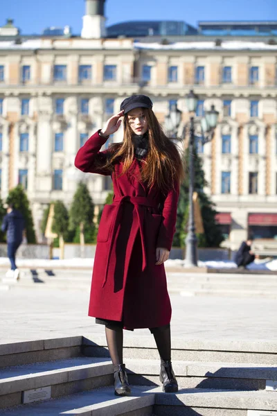 Bella ragazza in elegante in un lungo cappotto bordeaux — Foto Stock