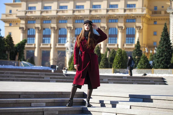 Bella ragazza in elegante in un lungo cappotto bordeaux — Foto Stock