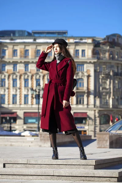 Bella ragazza in elegante in un lungo cappotto bordeaux — Foto Stock