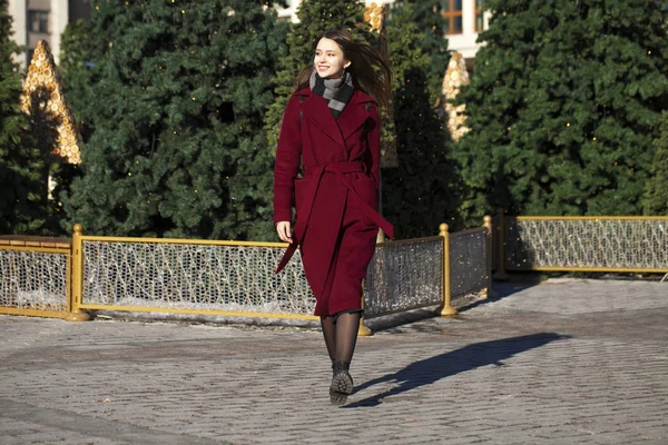 Hermosa chica con estilo en un largo abrigo de color burdeos — Foto de Stock