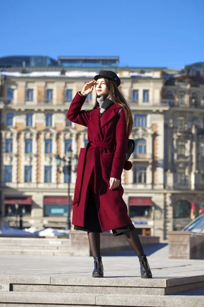 Bella ragazza in elegante in un lungo cappotto bordeaux — Foto Stock