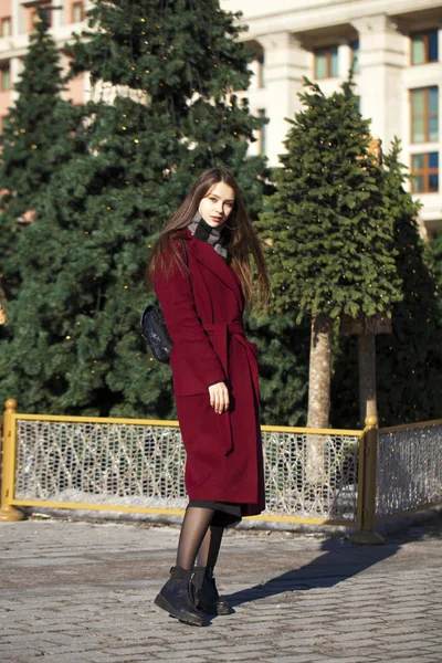 Красивая девушка в стильном длинном бургундском пальто — стоковое фото