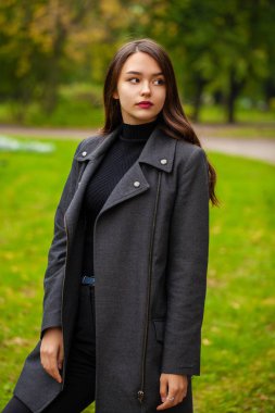 Gri paltolu güzel bir genç kadın portresi 