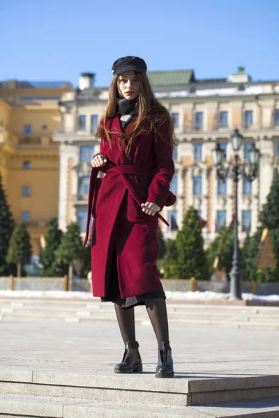 Bella ragazza in elegante in un lungo cappotto bordeaux — Foto Stock