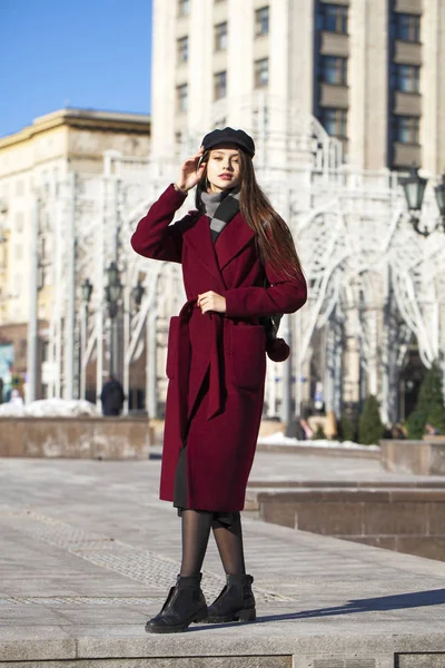 Menina bonita em elegante em um longo casaco de Borgonha — Fotografia de Stock