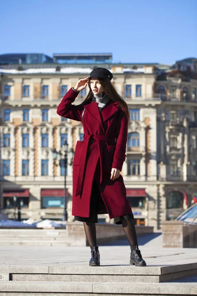 Bella ragazza in elegante in un lungo cappotto bordeaux — Foto Stock