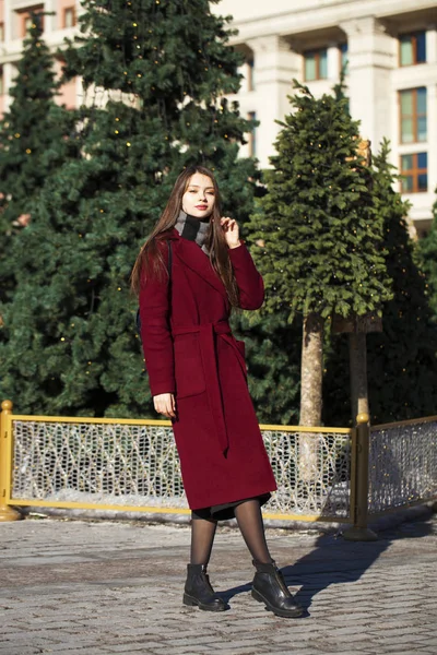 Bella ragazza in elegante in un lungo cappotto bordeaux — Foto Stock