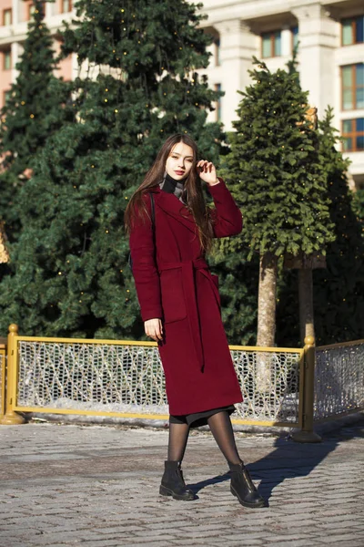 Hermosa chica con estilo en un largo abrigo de color burdeos — Foto de Stock