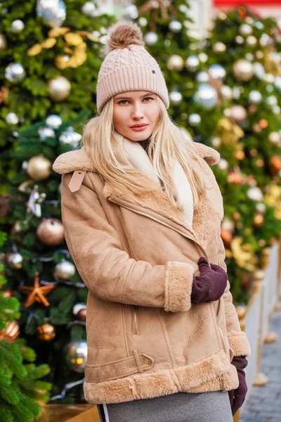 Mujer feliz en un abrigo de piel de oveja y sombrero de punto —  Fotos de Stock