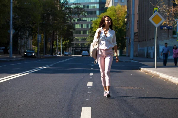 Junge schöne brünette Frau zu Fuß auf der Straße — Stockfoto