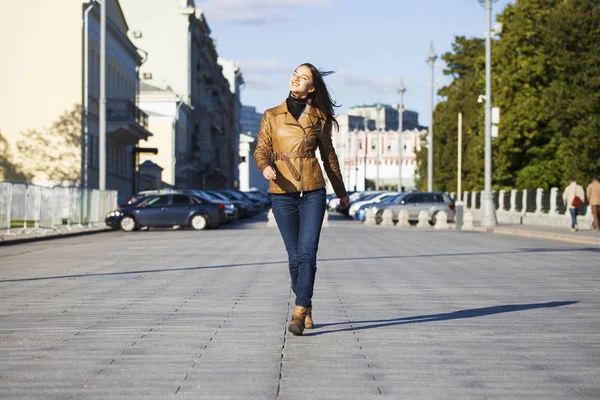 Ung glad kvinna i brunt läder jacka — Stockfoto