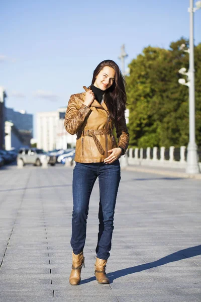 Ung glad kvinna i brunt läder jacka — Stockfoto