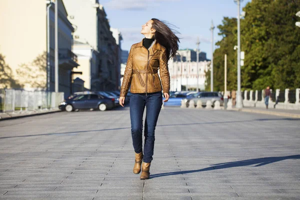 Ung glad kvinde i brun læderjakke - Stock-foto