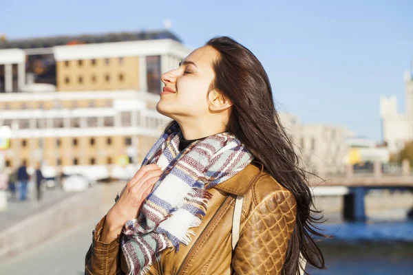 Молодая счастливая женщина в коричневой кожаной куртке — стоковое фото